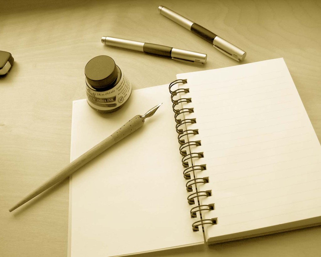 ink bottle, pens, notebook